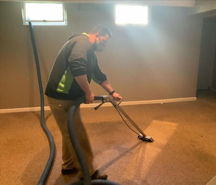 SERVPRO technicians with extraction wand on wet carpet