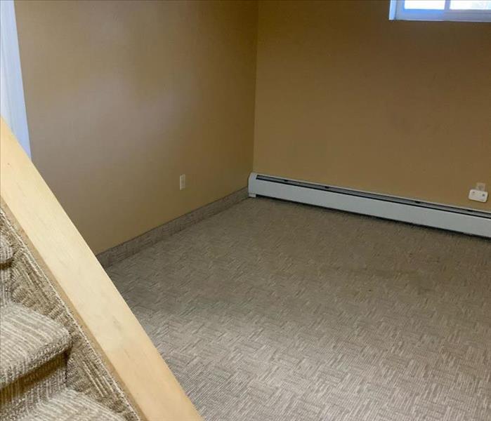 Empty storage room with ochre walls and patterned carpet