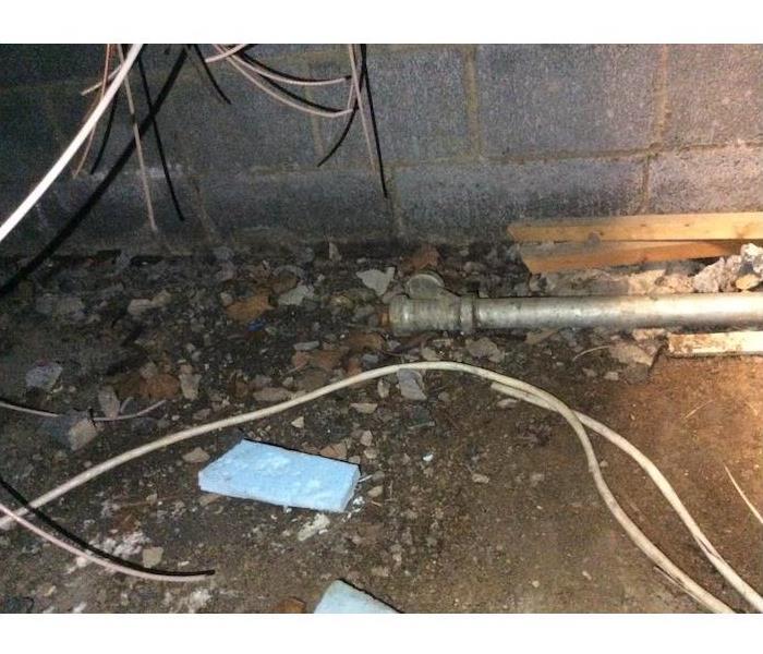 Crawlspace floor with pipe, debris, and dirt