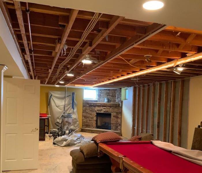 Exposed ceiling and bare floor in gameroom with pool table