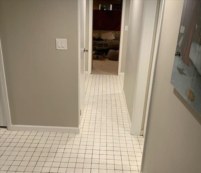 Hallway with white tile and wood floorboards