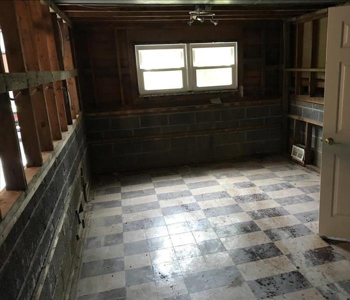Room with black and white tile floor and framework showing