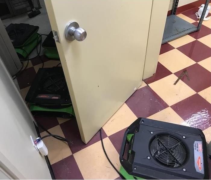 SERVPRO air movers on wet tile floor with commercial water damage