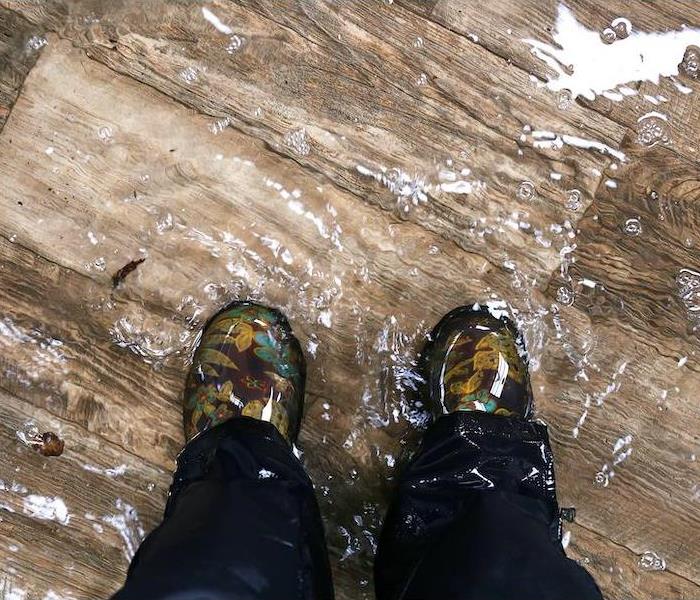 Standing in a pool of flooding water in a home.