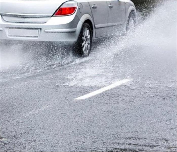 Car Driving Through Water in The Road