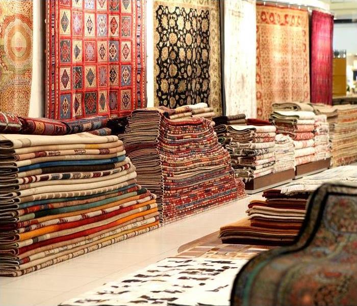 Rug showroom; rugs stacked and hung on wall