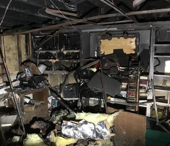 fire damaged living room with soot-covered items and debris